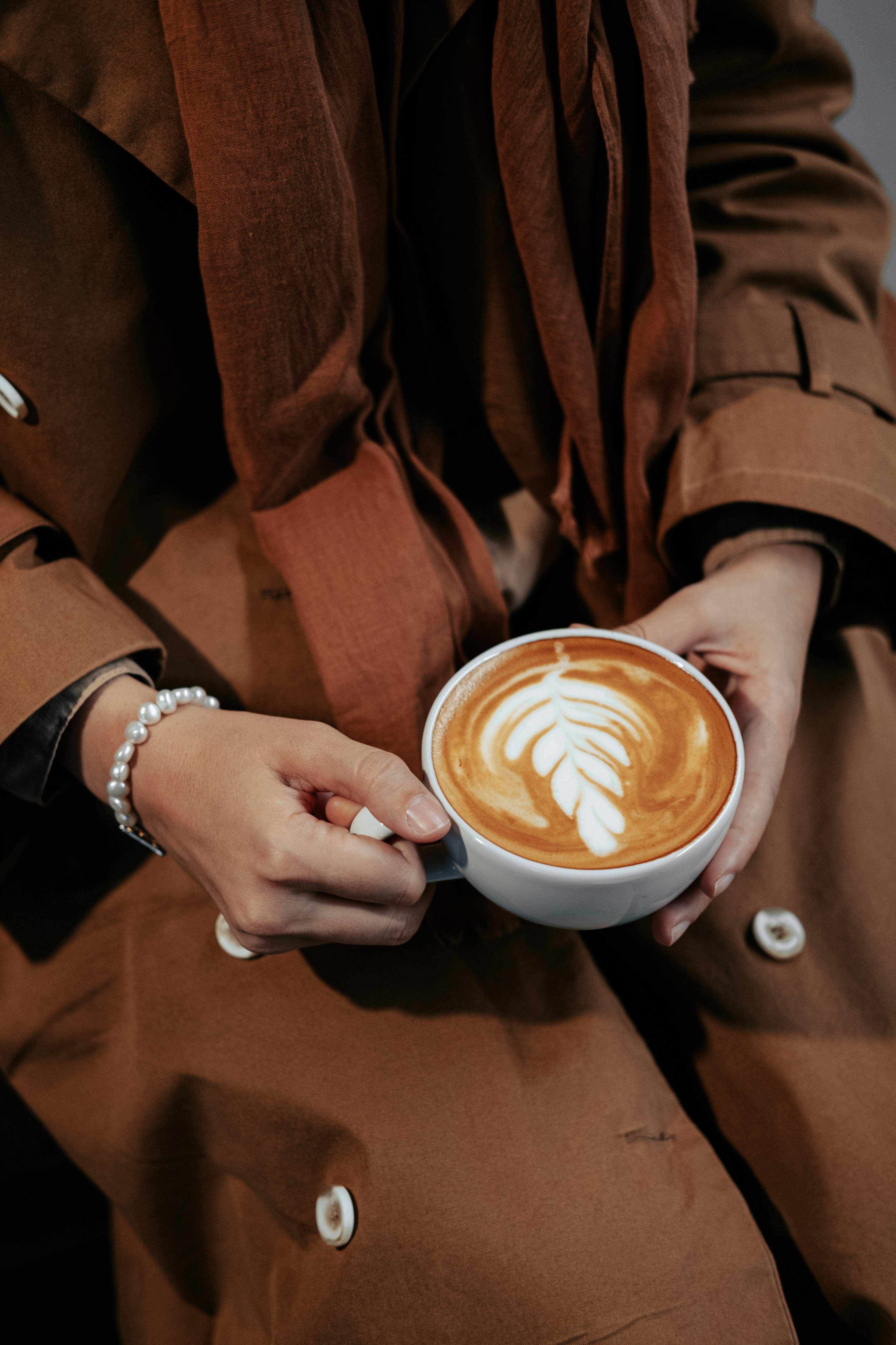 Latte with leaf art held in both hands at the MODE café