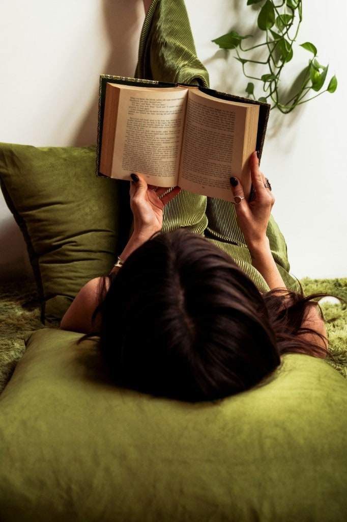 Guest reading on a green lounge in the MODE wellness space