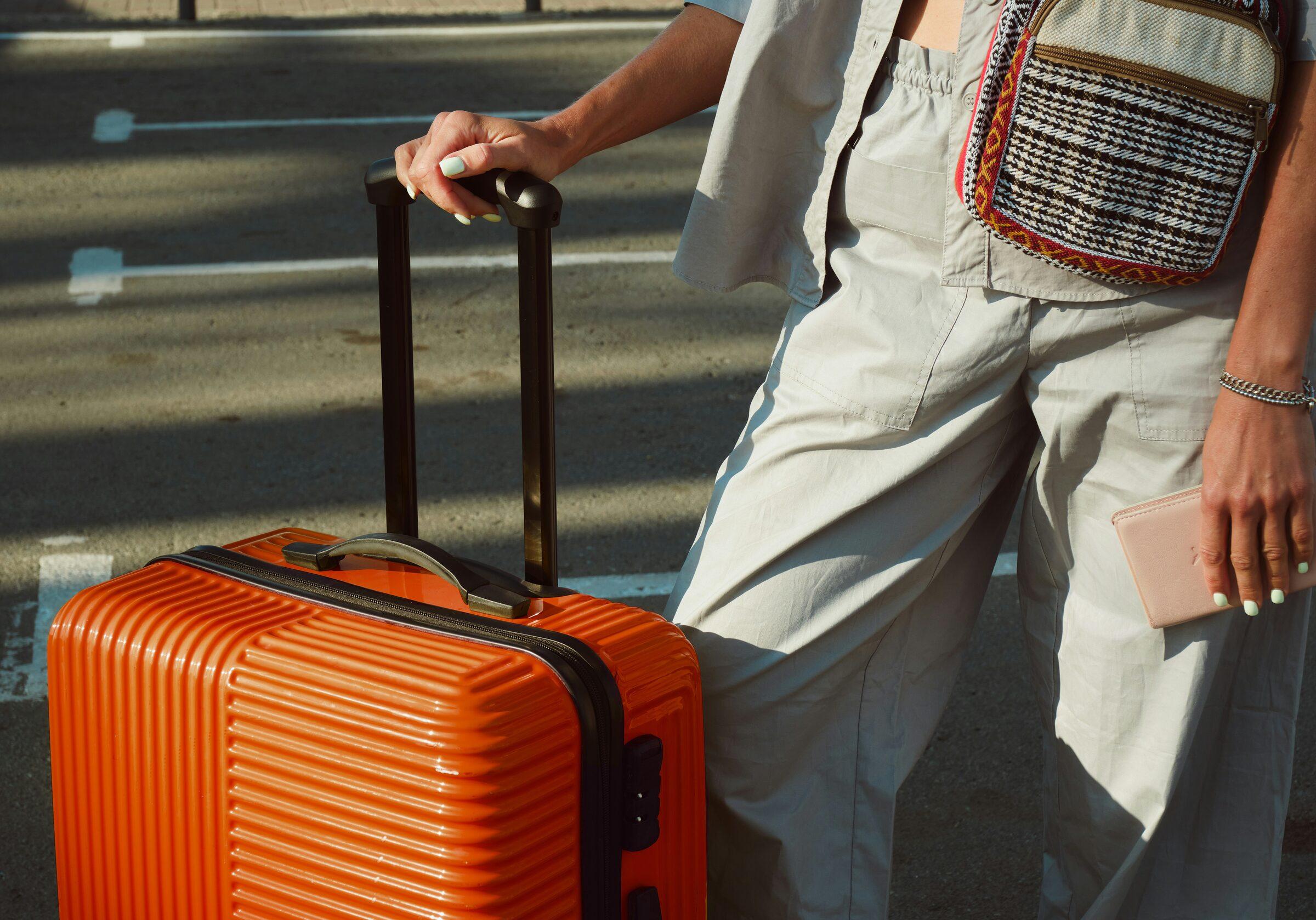 Traveller with a bright orange suitcase arriving at MODE by YHA Sydney