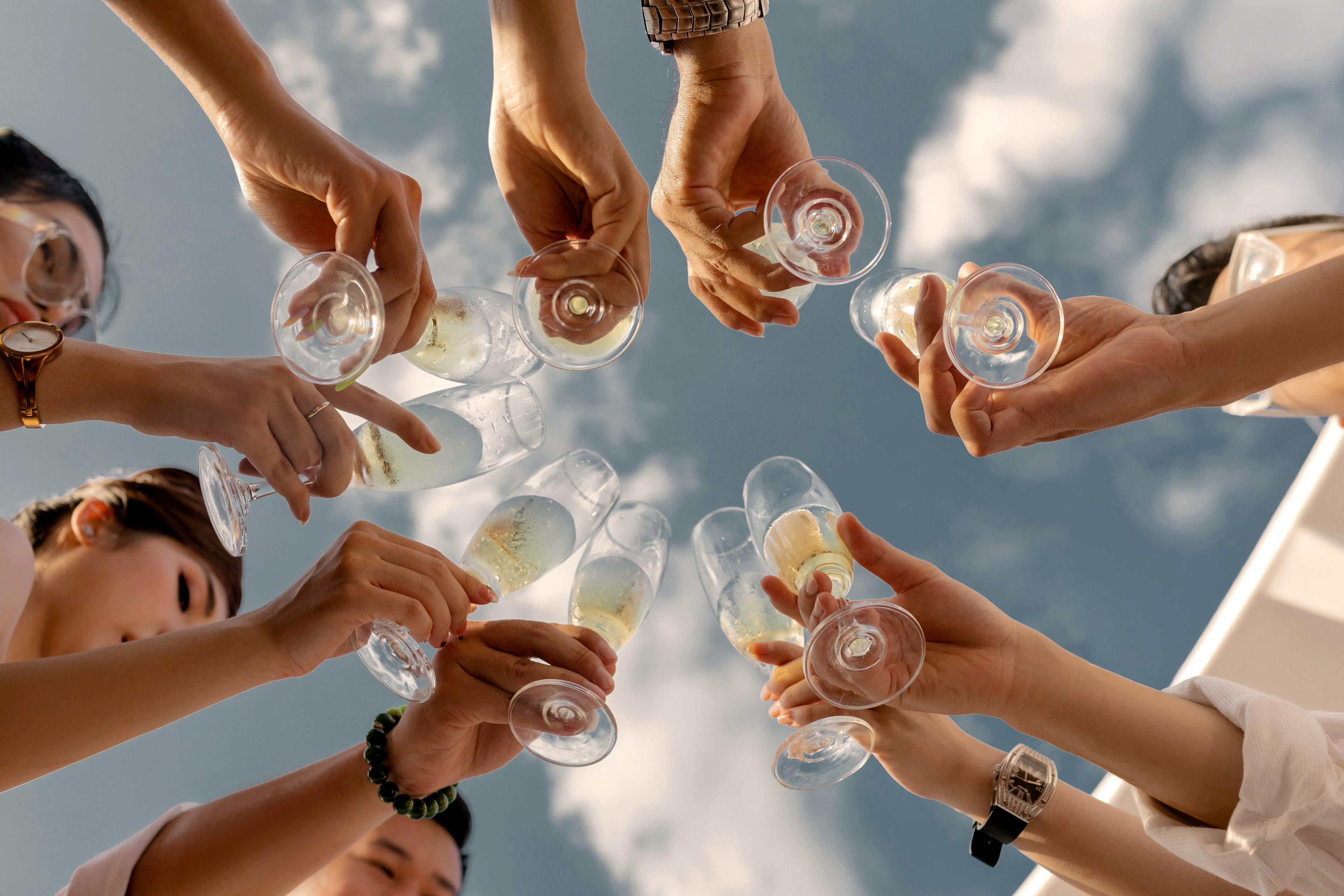 Friends toasting champagne flutes outdoors at MODE Social by YHA